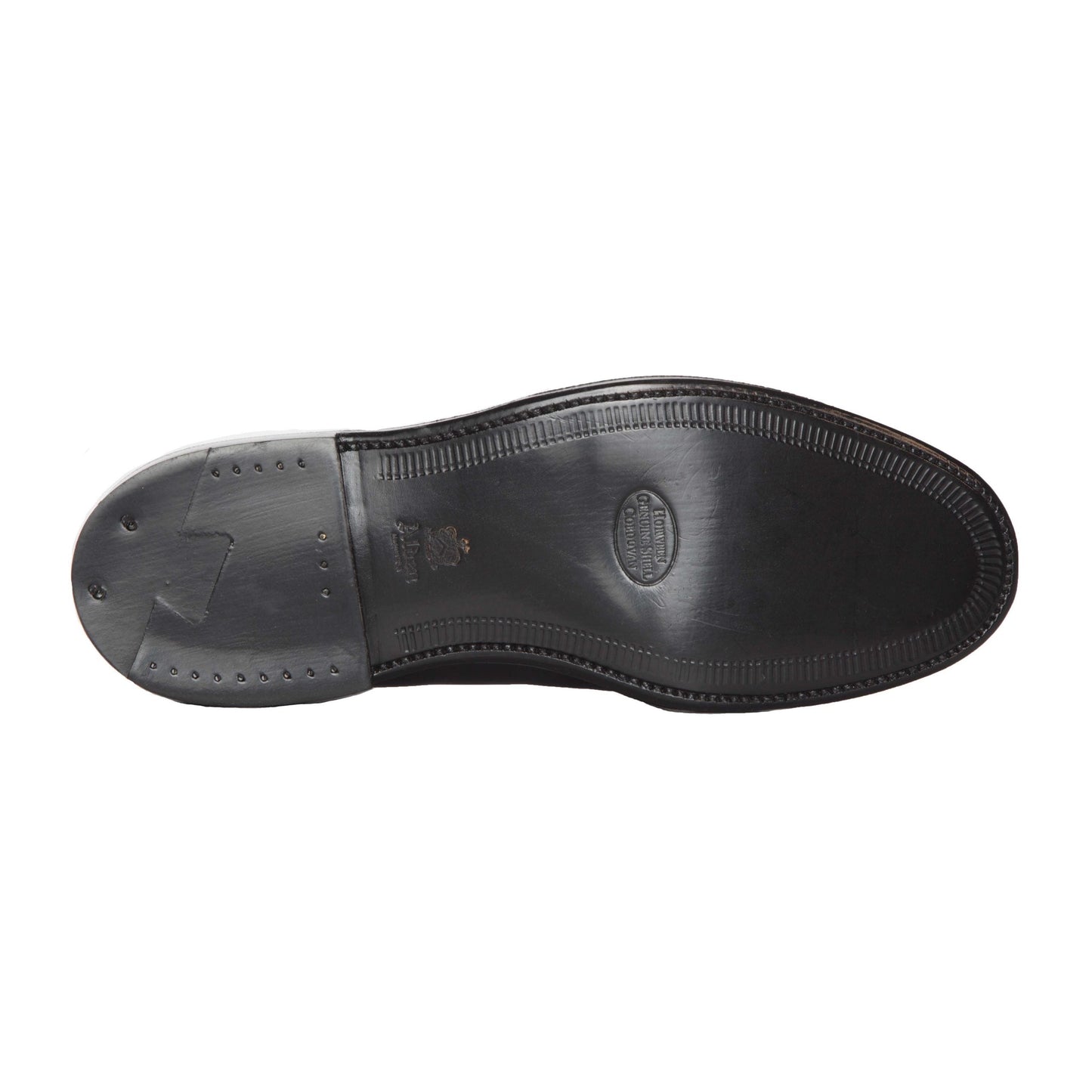 The image reveals the sole of a Black Shell Cordovan leather shoe by Alden Madison, with a textured edge, small nail details near the heel, and a central embossed logo. This is part of the 1340 - Chukka Boot in Black Shell Cordovan collection.