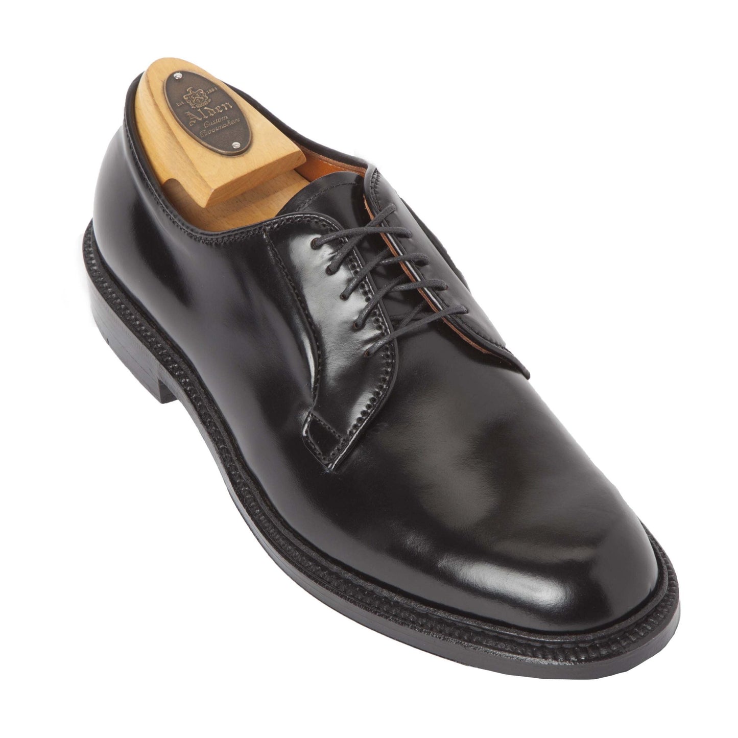 The Alden Madison 9901C is a black shell cordovan Plain Toe Blucher with a commando sole, featuring laces and a smooth finish. It comes with a wooden shoe tree that includes an unreadable plaque.