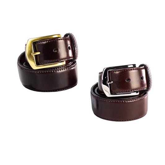 Two rolled-up Alden Madison MB 5918 - Alden 38mm Color 8 Shell Cordovan Belts, one with a gold and the other with a silver buckle, are displayed side by side on a white background. Each is 38mm wide and made in the USA.