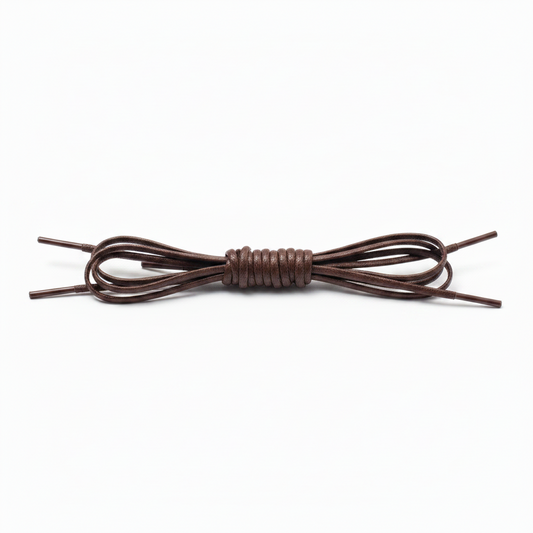 A single ALDEN SHOES Laces - Chukka boot 21 inch lace is coiled neatly at the center with its ends extending outward on both sides, displayed against a plain white background.