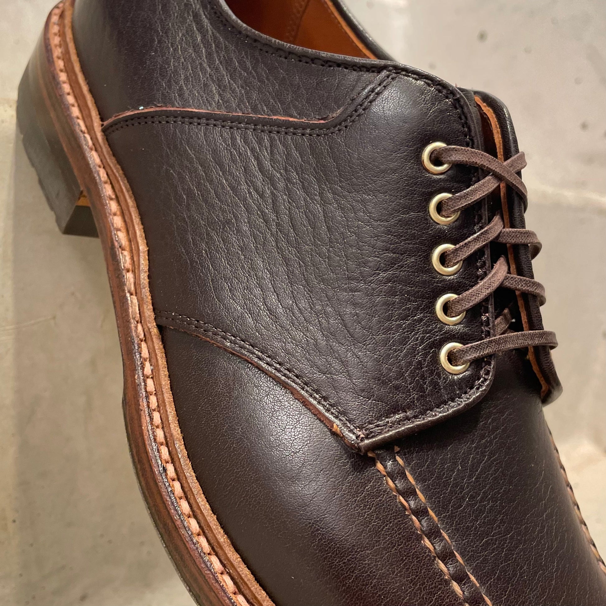 Close-up of Alden Madisons D1613C The Belmont Saddle Blucher in rich Arabica Calf—features textured upper, contrast stitching, metal eyelets, brown laces, and sturdy Commando sole to showcase exceptional craftsmanship.