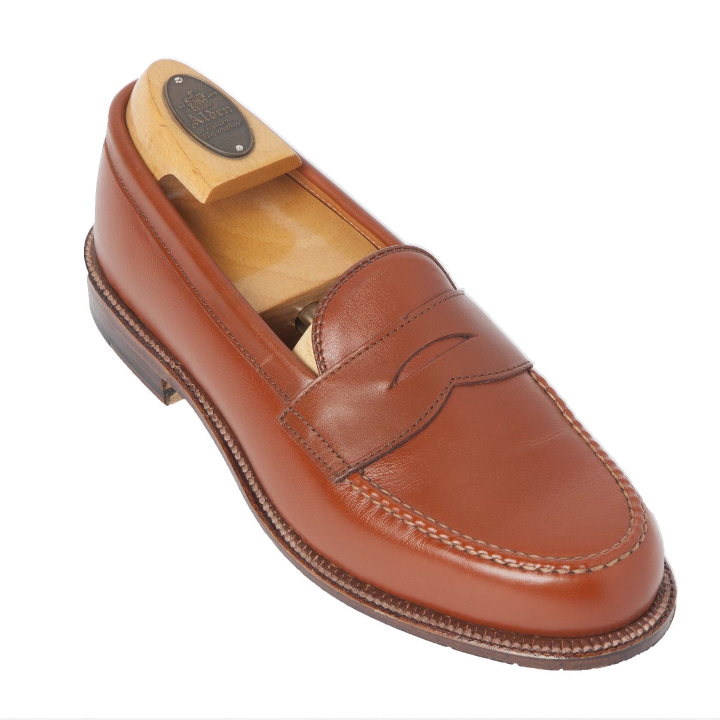 The Alden Madison 983 Leisure Hand Sewn loafer features burnished tan calfskin leather, detailed stitching, a classic penny strap on the Van last, and a single oak leather outsole with a slightly raised heel.