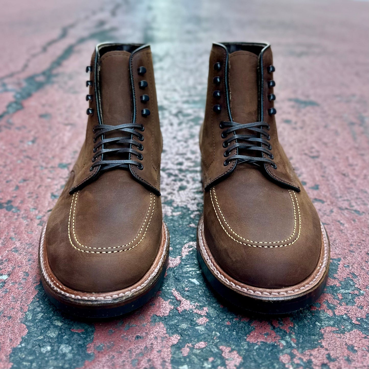 The D2909H - Indy Boot by Alden Madison showcases a rugged look with black laces on worn red and gray surfaces, contrast stitching, and a sturdy sole that embodies the Trubalance Last in Tobacco Smooth Chamois.