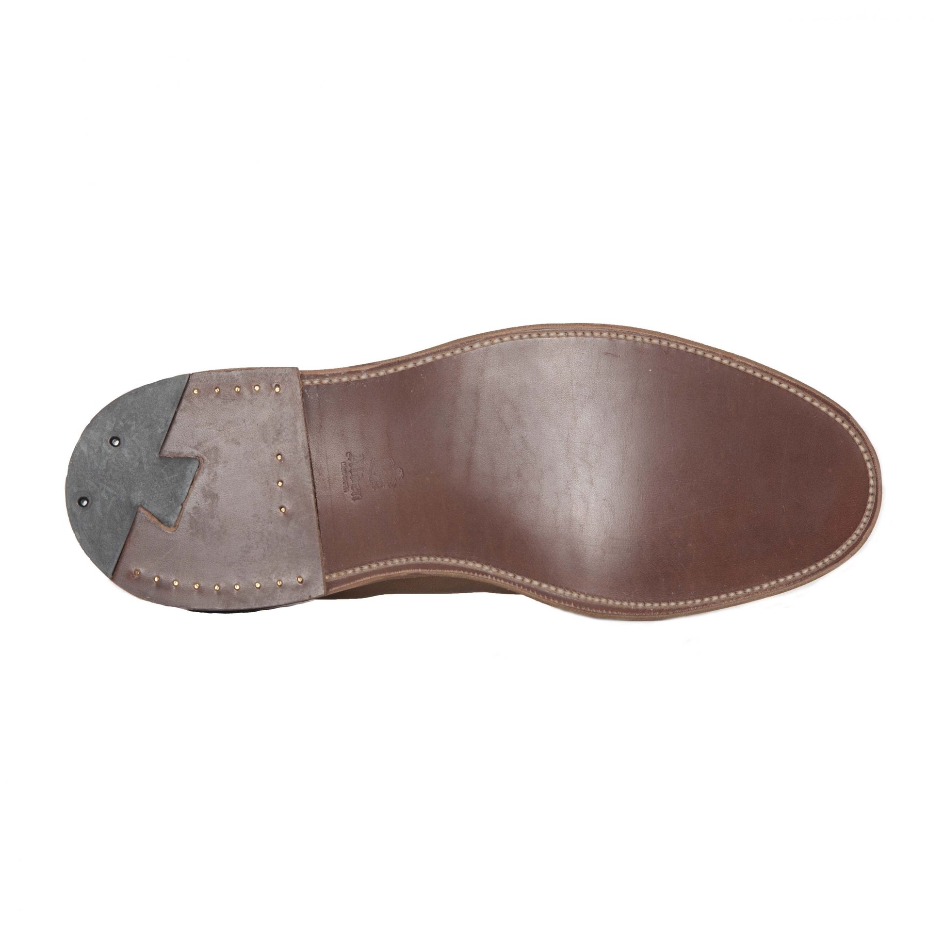 The image shows the sole of a black calfskin shoe crafted on the Copley Last by Alden. It features edge stitching, a contrasting dark heel with metal reinforcements, and a small zigzag design for added flair.