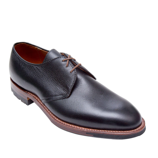 The Alden Madison 940C - 3 Eye Dutton shoe, made from Black Alpine Grain Calfskin, features brown laces and a Commando Sole. This classic lace-up design is crafted on the Hampton Last, offering comfort and timeless elegance against a white background.