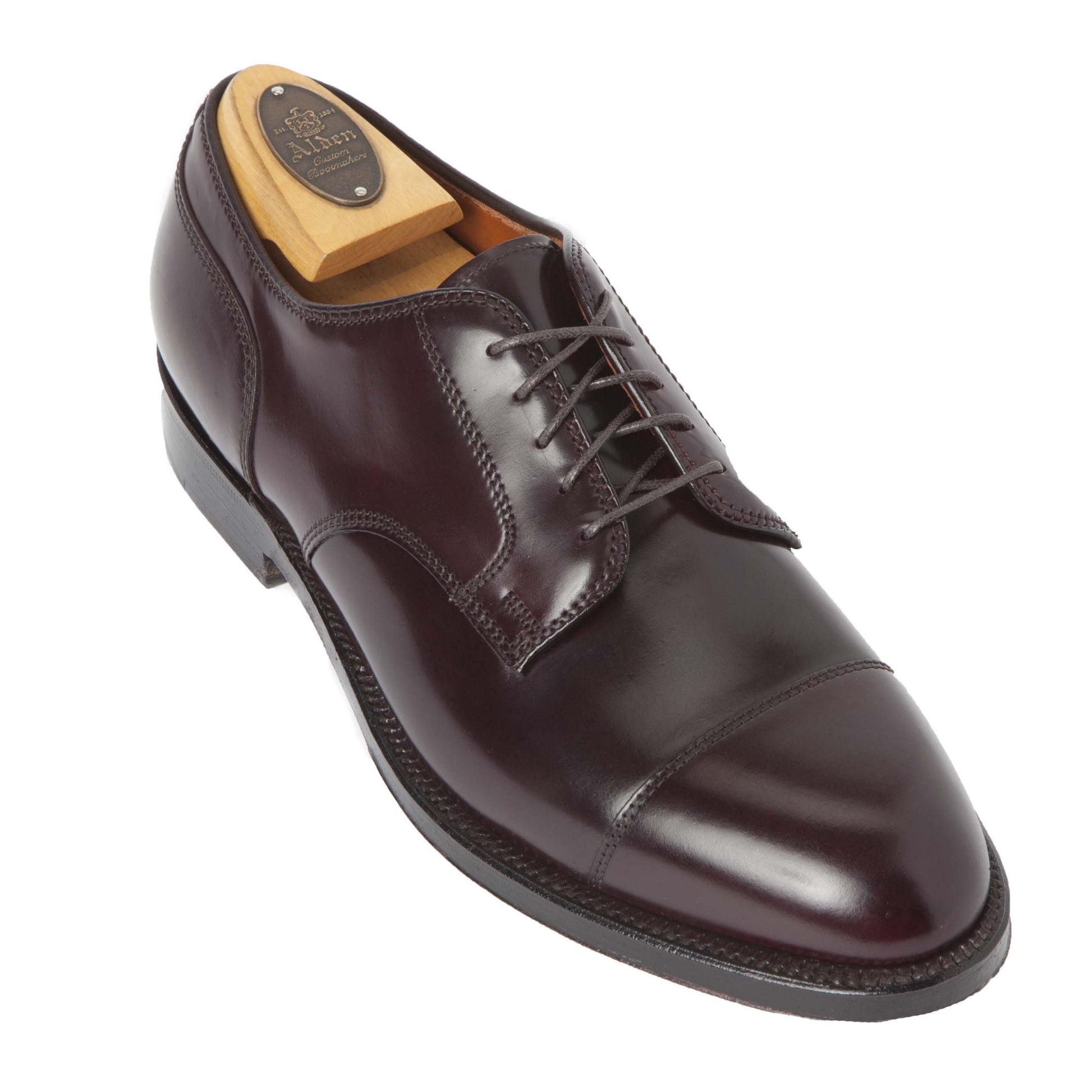 Alden Madisons 2160 Cap Toe Blucher in Color 8 Shell Cordovan is a polished dark brown leather dress shoe with detailed stitching, a leather outsole, and Alden-branded wooden shoe tree. It features the sleek Aberdeen Last and is posed at an angle on a white background.