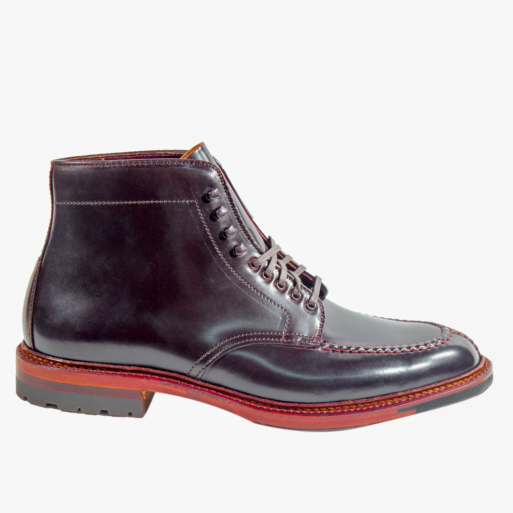 The Alden Madison 40218HC - NST Tanker Boot in Color 8 Shell Cordovan is a polished dark brown leather ankle boot crafted on the Barrie Last. It features red stitching, a red-brown sole with textured black Commando Sole, six eyelets, and a rounded toe, showcasing high-quality craftsmanship.