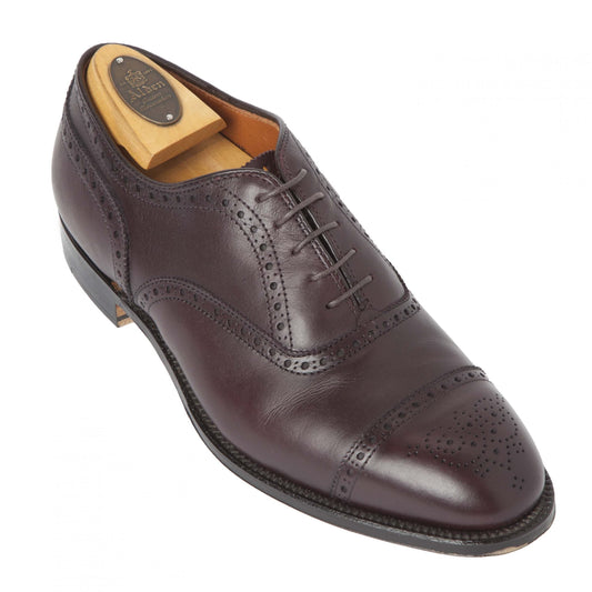 Alden Madison’s Medallion Cap Toe Bal in rich burgundy calfskin features brogue detailing and a cap toe, crafted on the elegant Hampton Last with a classic leather sole, shown here with a wooden shoe tree inside.