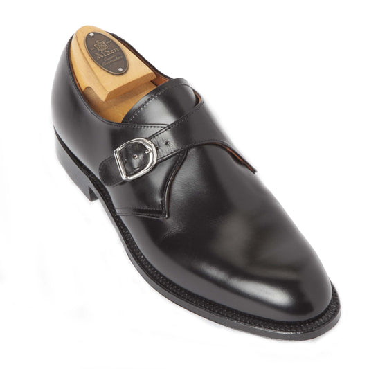 The Alden Madison 955 - Monk Strap in Black Calfskin features a polished design with a single nickel buckle and leather sole. It includes a wooden shoe tree, making it ideal for formal occasions.