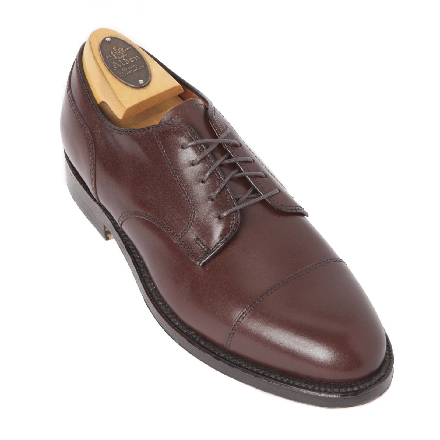The 972 - Cap Toe Blucher in Walnut Brown by Alden Madison is a polished calfskin leather dress shoe with a cap toe design, dark laces, and an emblem on the insole. Designed on the Aberdeen Last, it features sleek stitching and a refined angled front.