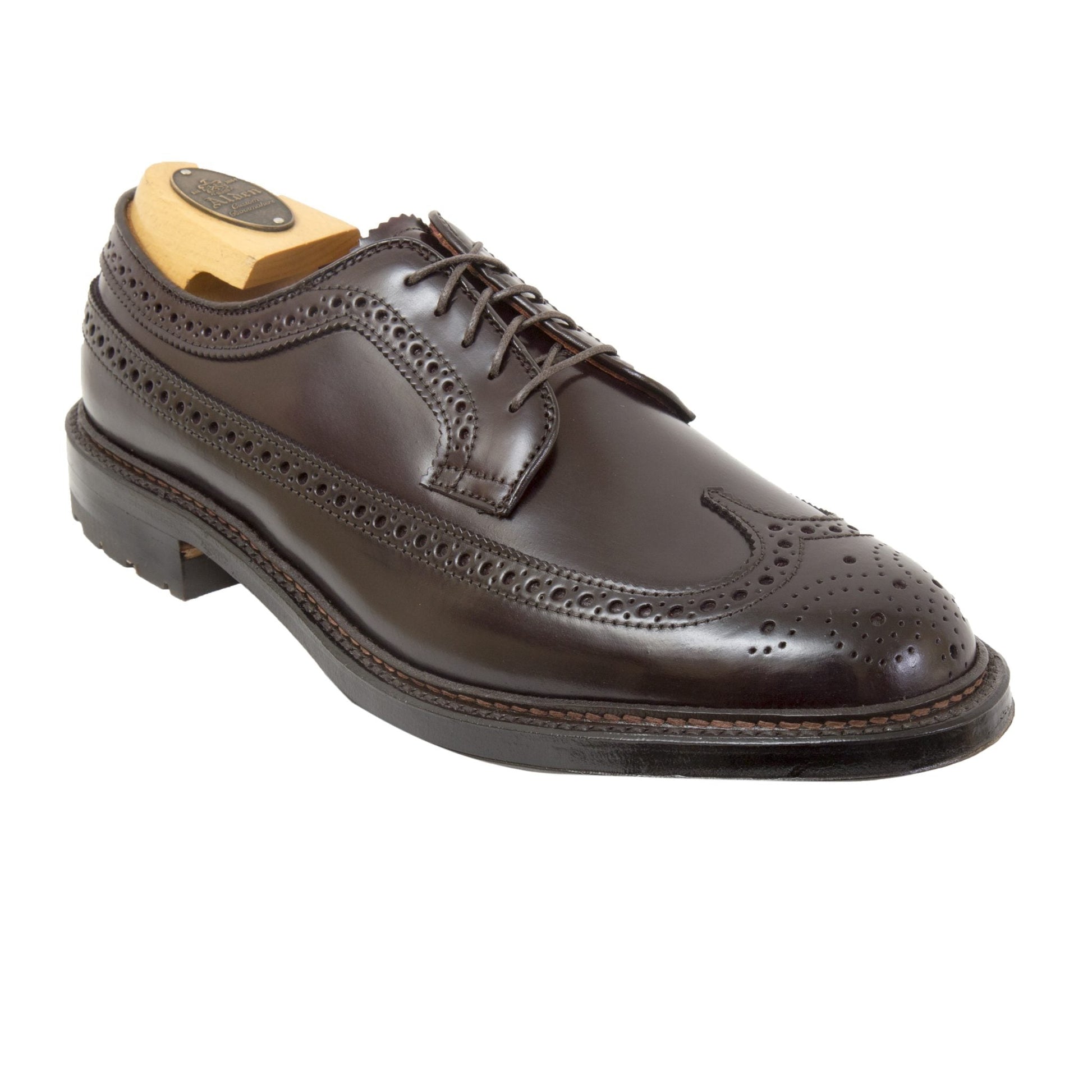 The Alden Madison 975C Long Wing dress shoe in Color 8 Shell Cordovan with a commando sole features brogue detailing, laces, and a wooden shoe tree inside, shown against a white background.