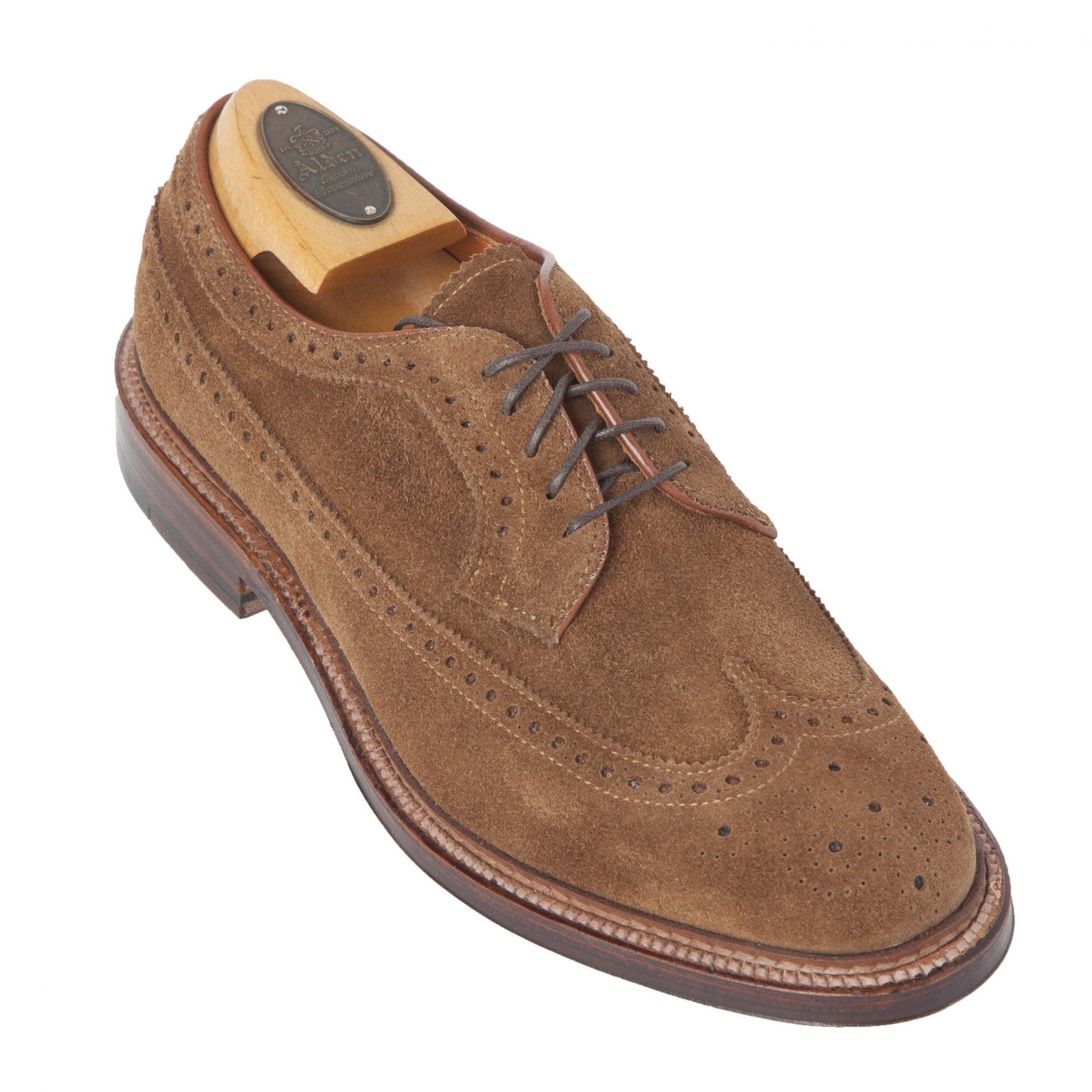 The Alden Madison 9794 Long Wing Blucher in Snuff Suede features a wingtip design with brogue detailing, dark brown laces, a wooden shoe tree, and a textured Waterlock leather sole on the Barrie last with a round toe.