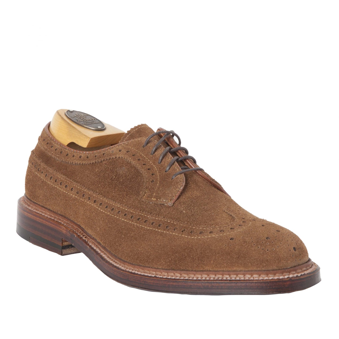 The Alden Madison 9794 Long Wing Blucher in Snuff Suede features decorative perforations, a wooden shoe tree inside, and a Waterlock leather sole with wooden detailing. Crafted on the Barrie last, it offers a perfect blend of style and comfort.