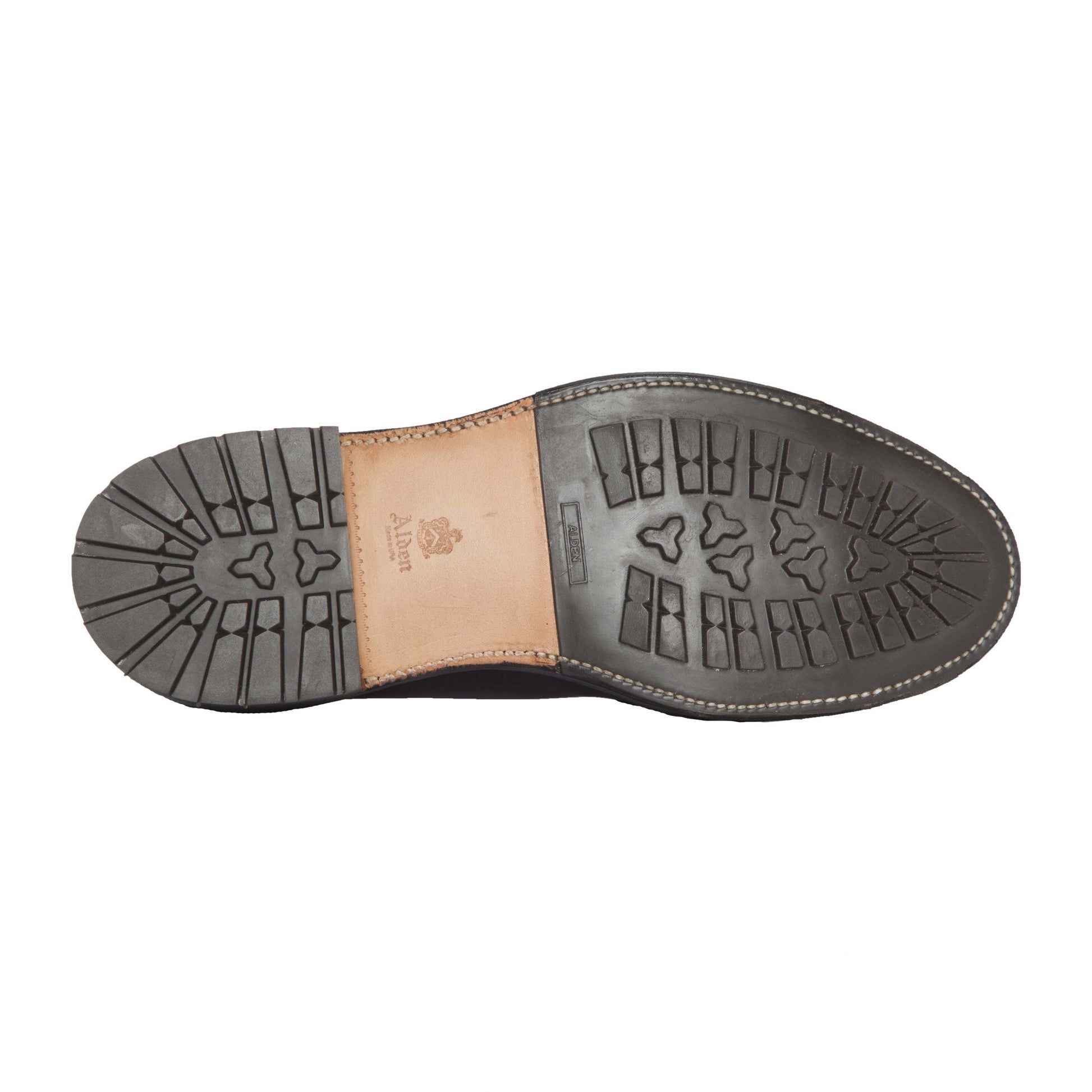 The image shows the sole of the Alden Madison 4012HC Indy Boot in Brown Rusticalf, featuring a black rubber 360 Commando Sole with rectangular and triangular tread, a brown leather midsection stamped Alden, and white edge stitching.