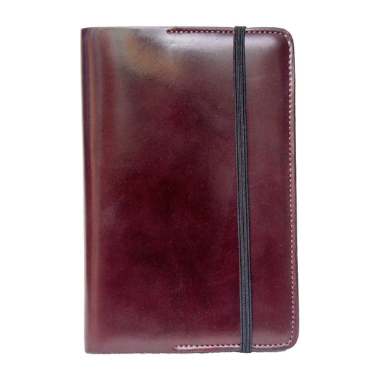 Alden Madison's Moleskine Notebook Cover is a compact, closed case made from luxurious brown Horween leather, featuring a black elastic band that wraps vertically around it and displayed against a white background.