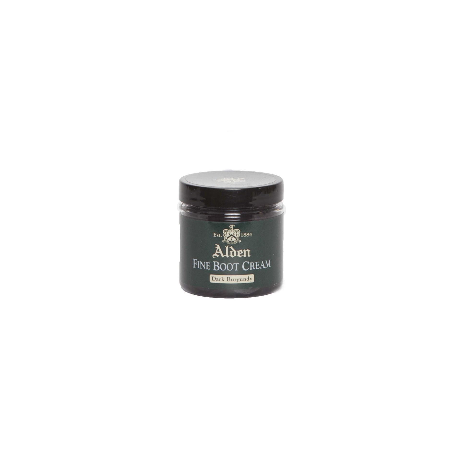 A small jar of Alden Boot Cream by Alden Madison, in Dark Burgundy, ideal for enhancing calfskin leathers. It has a black lid and label with white and gold text, featuring a crest logo. The jar is centered on a plain white background.