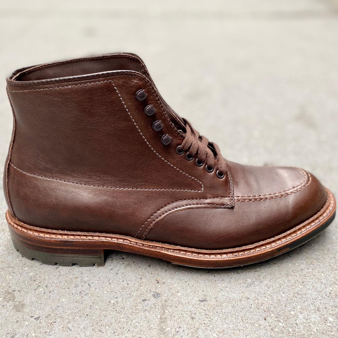 The Alden Madison 4012HC Indy Boot in Brown Rusticalf features visible stitching, metal eyelets, and a durable 360 Commando Sole, shown here on a concrete surface.
