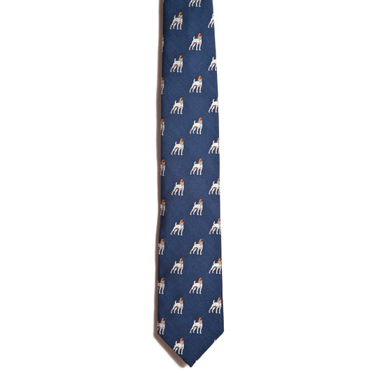 A blue silk necktie from Alden Madison features a playful pattern of small Jack Russell Terriers wearing red bows, displayed on a white background.