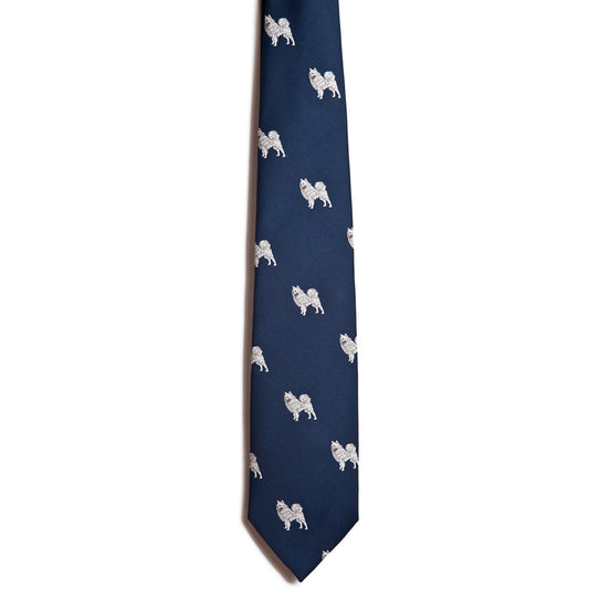 The Alden Madison Samoyed necktie is navy blue silk jacquard, featuring a pattern of small white Samoyed dogs embroidered and evenly spaced across the fabric, shown on a white background.