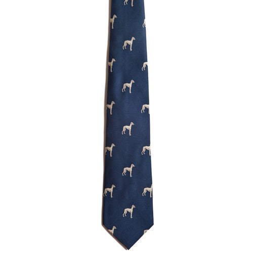 The Alden Madison Whippet tie is a blue silk jacquard necktie with a repeating pattern of small white dog silhouettes—ideal for dog lovers seeking a stylish Whippet-themed accessory.
