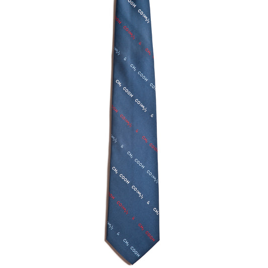 The Piss and Vinegar blue silk tie by Alden Madison features vintage diagonal red and white text patterns with CH, COOK, and & on a pristine white background, adding a novel touch to this sleek, formal necktie.